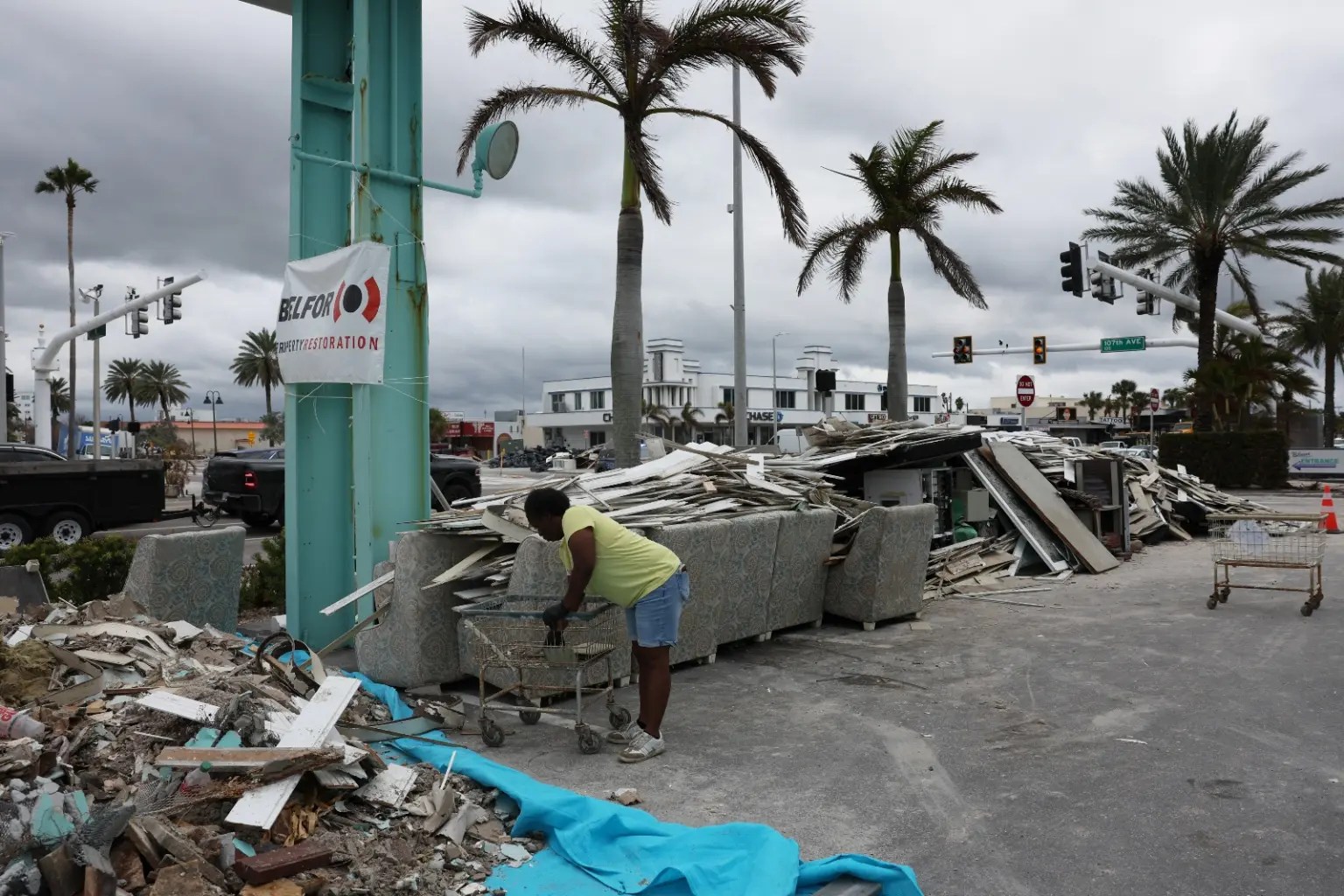 someone bends over in front of debris.