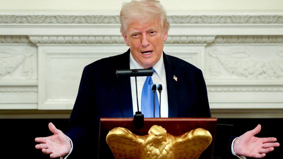 Donald Trump stands at a podium with his hands spread out.