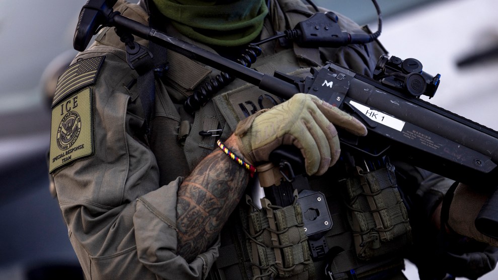 Close-up of ICE agent holding a less-lethal weapon.